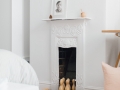 White Victorian cast iron fireplace | Wooden skittles | Illustrative prints | A modern neutral millennial pink bedroom for children with handmade furniture, personalised artwork and statement lighting